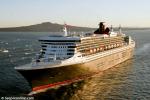 ID 3732 QUEEN MARY 2 (2003/148528grt/IMO 9241061) with the first rays of sun gilding her hull, leaves Rangitoto Ialand astern as she glides into the inner reaches of Aucklands' Waitemata Harbour escorted by...
